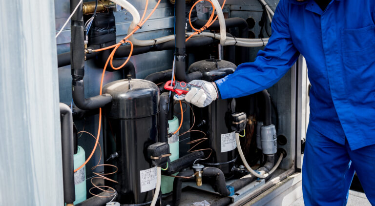 The technician checking power lines of the heat exchanger with current clamps